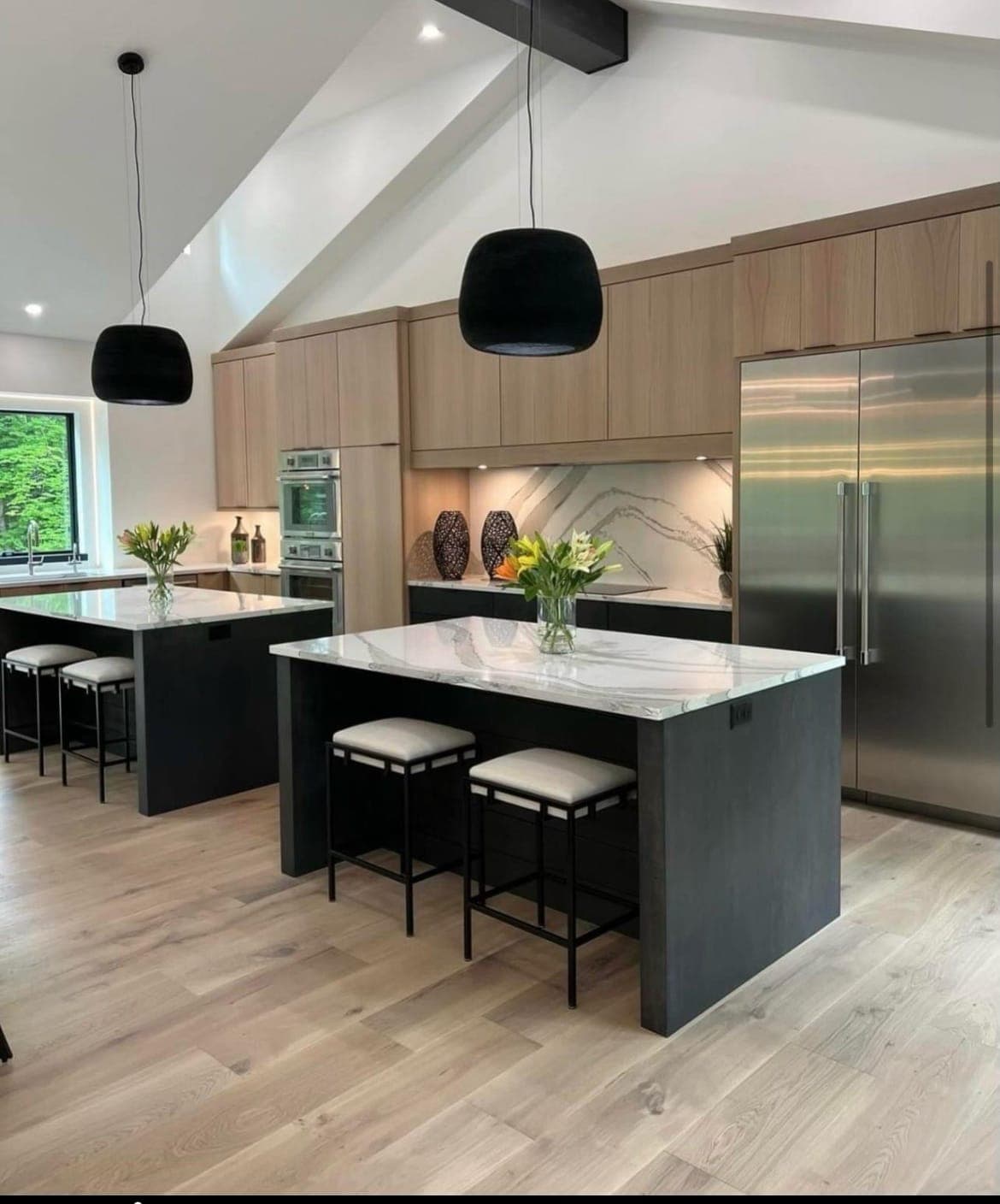 Modern open-concept kitchen with light engineered hardwood floors and dual islands